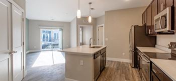 An empty kitchen with a sink and a refrigerator